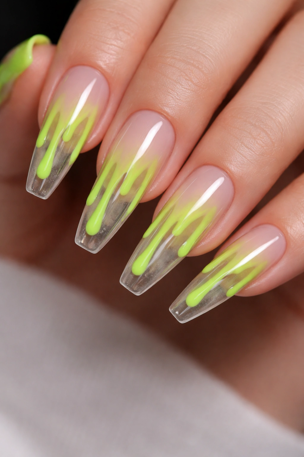 Neon green drip art on clear-based ballerina nails with glossy finish