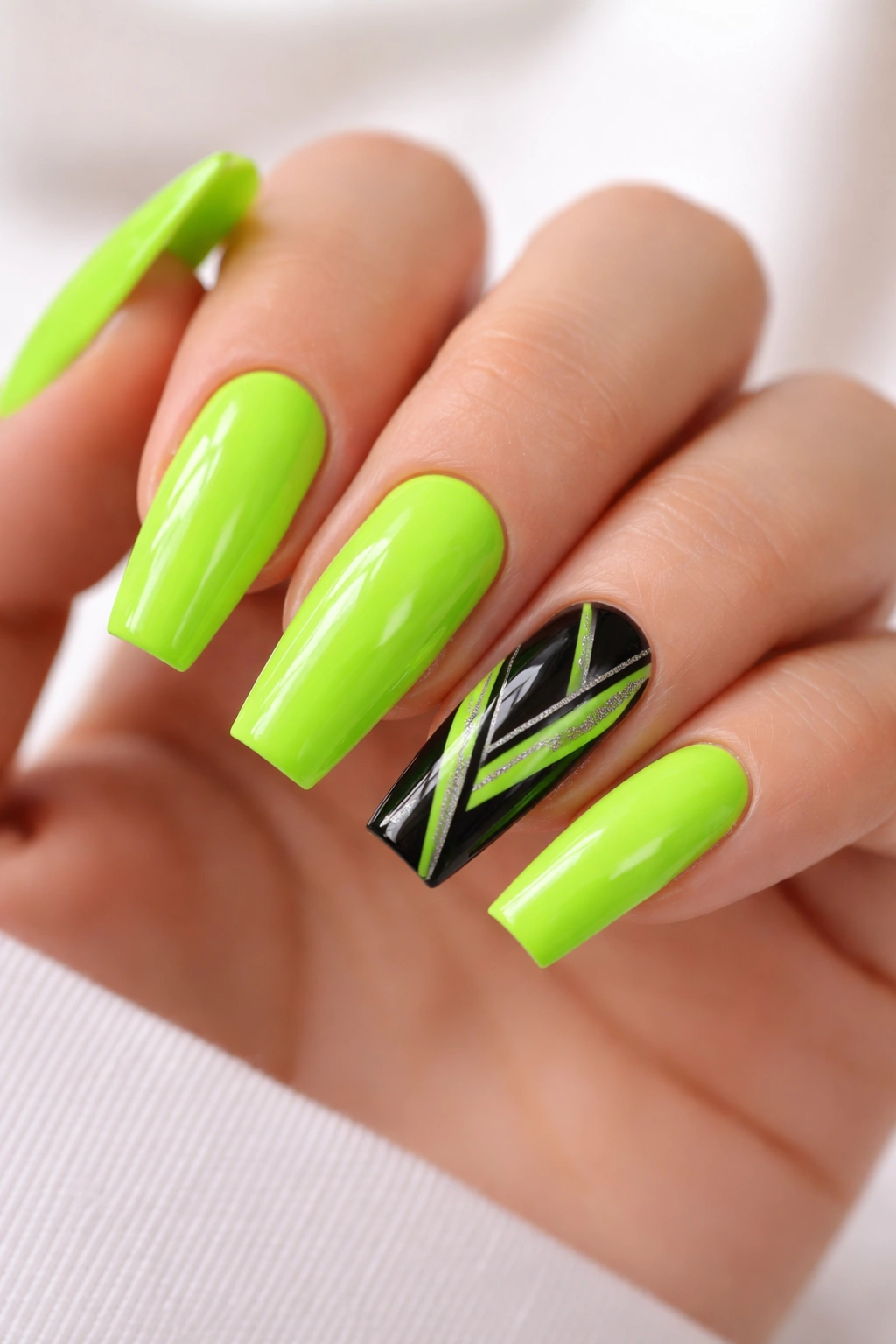 Close-up of neon green nails with black nail design