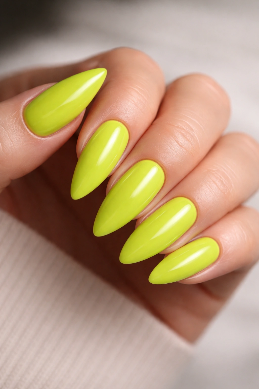 Neon lime almond nails with glossy finish.