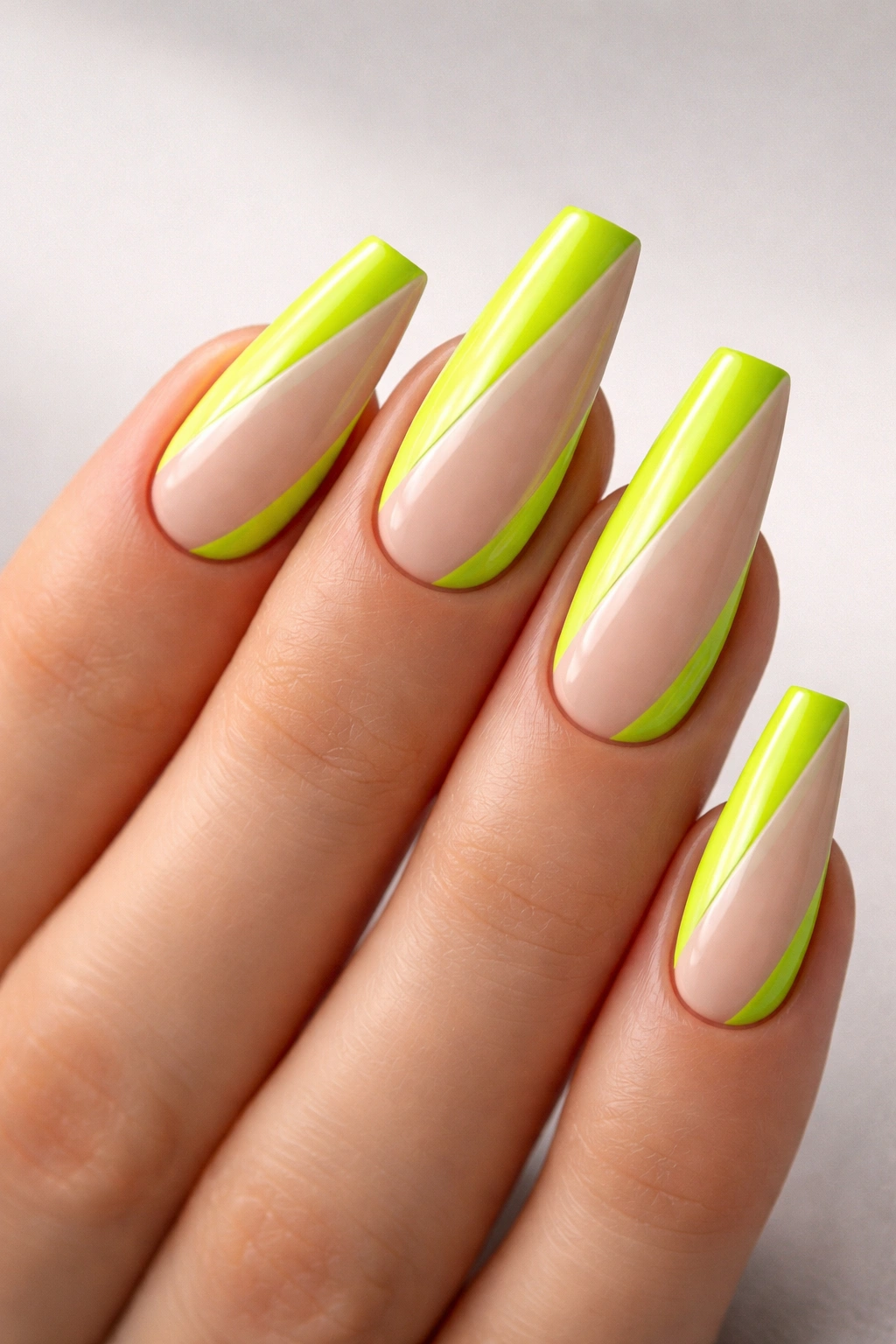 Close-up of acid green and nude color-block ballerina nails with a diagonal nude panel.