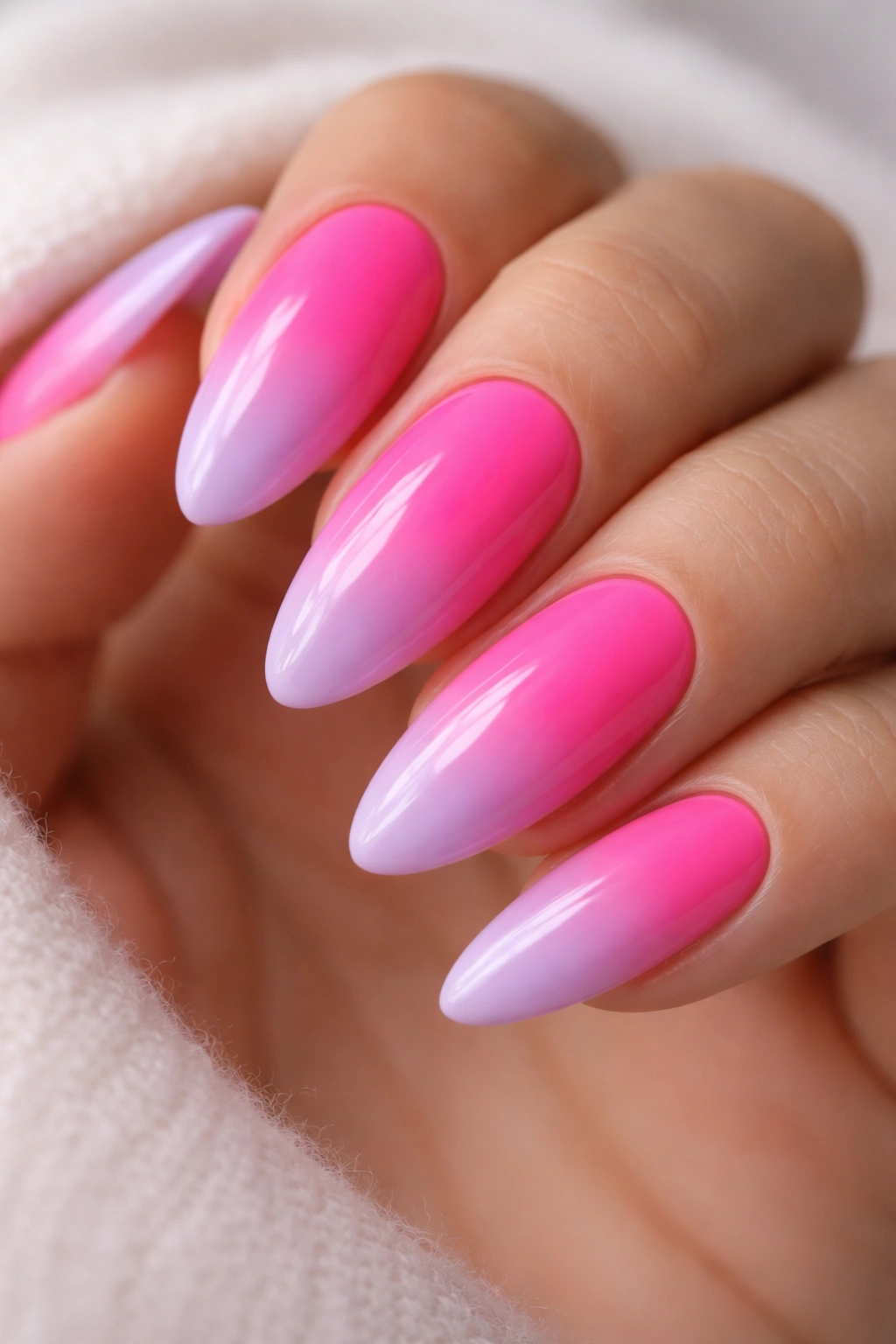 Almond nails in neon pink to lilac gradient under studio lighting