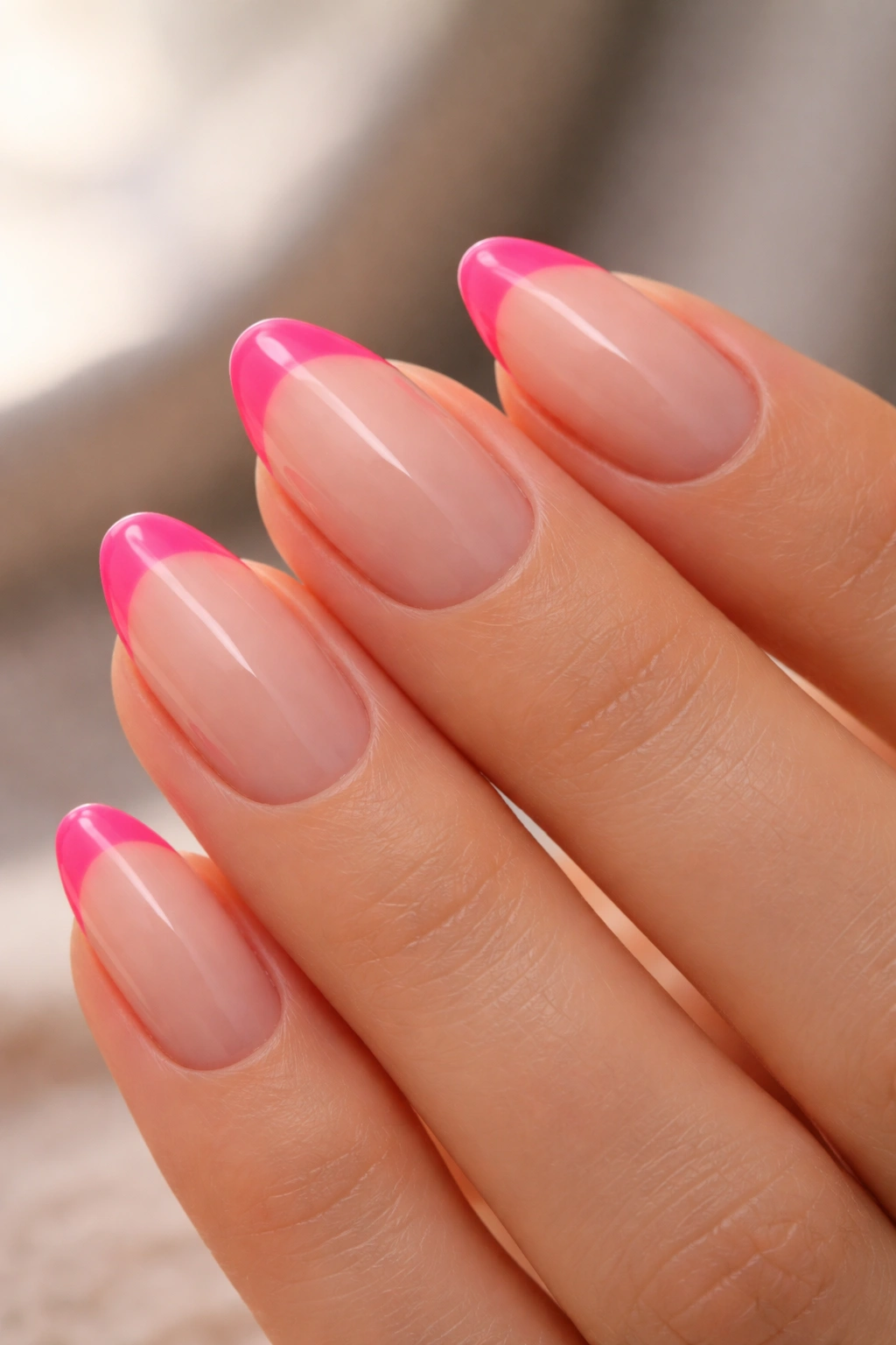 Short almond nail with neon pink tip over sheer nude base