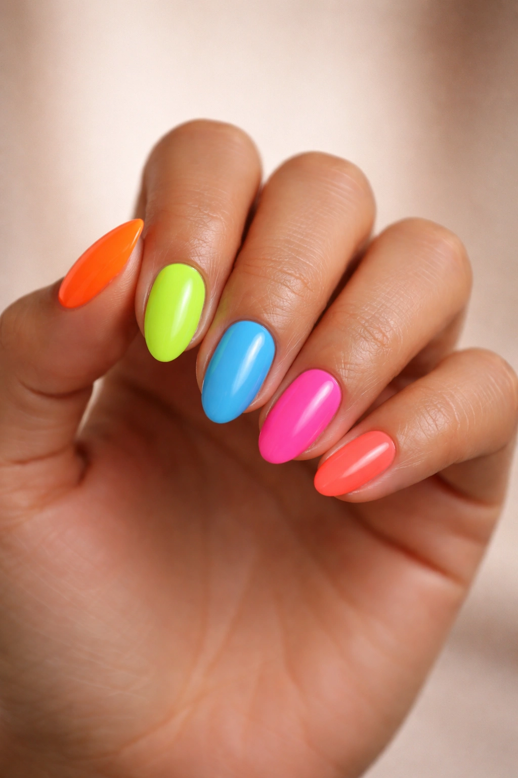 Close-up of hand with multi-color neon nails showing skin-tone contrast