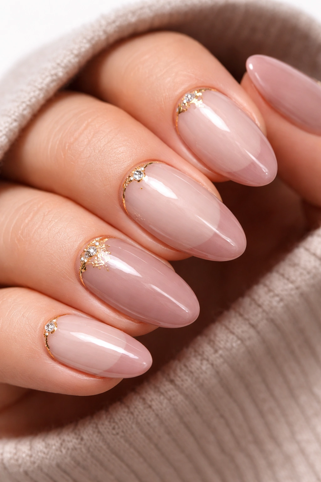 Neutral nails with gold accents and soft pink tips