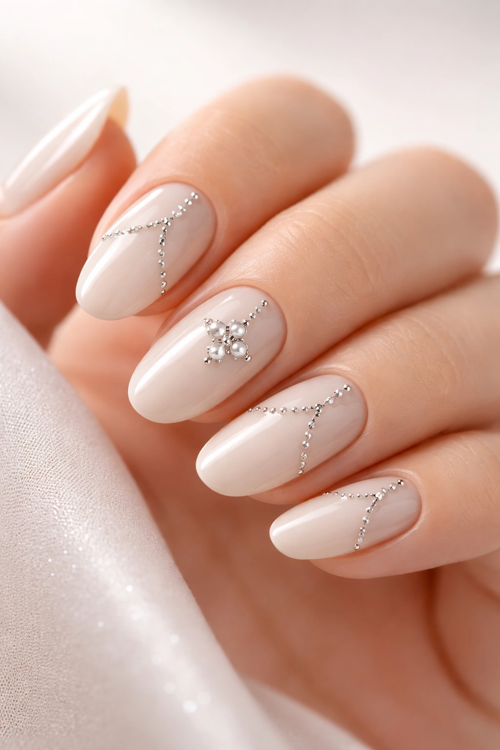 Beige nails with small silver studs in a delicate pattern