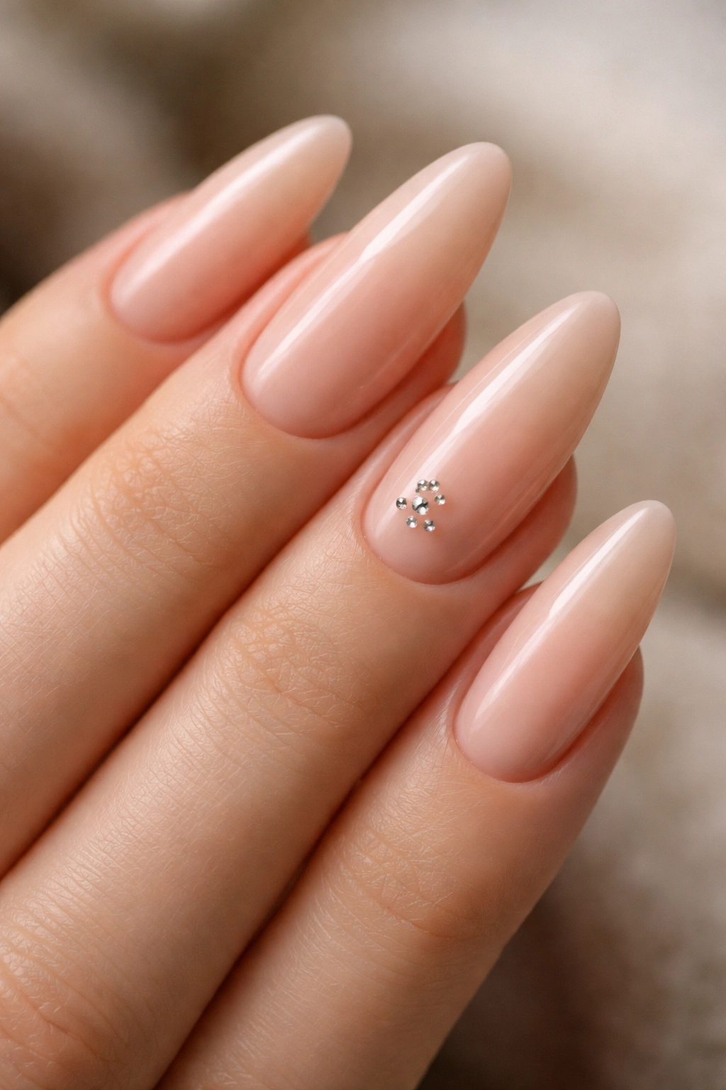 Nude almond nails with micro rhinestones near the cuticle