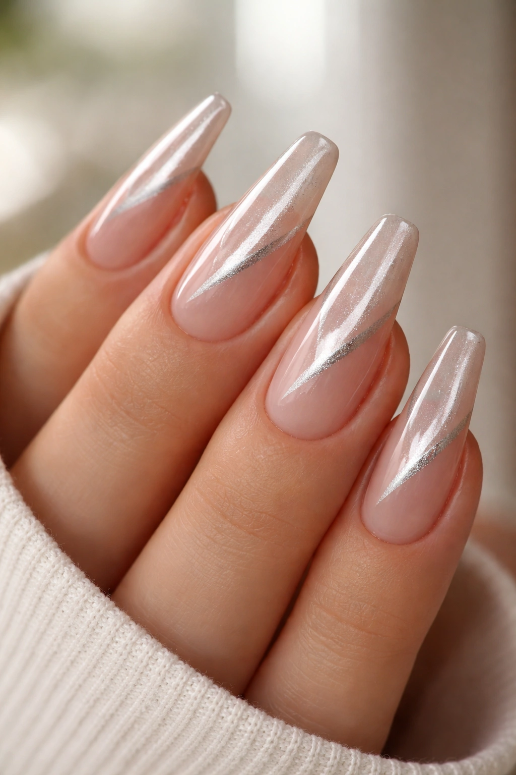 Nude base nails with a diagonal silver cat-eye stripe on ballerina nails.