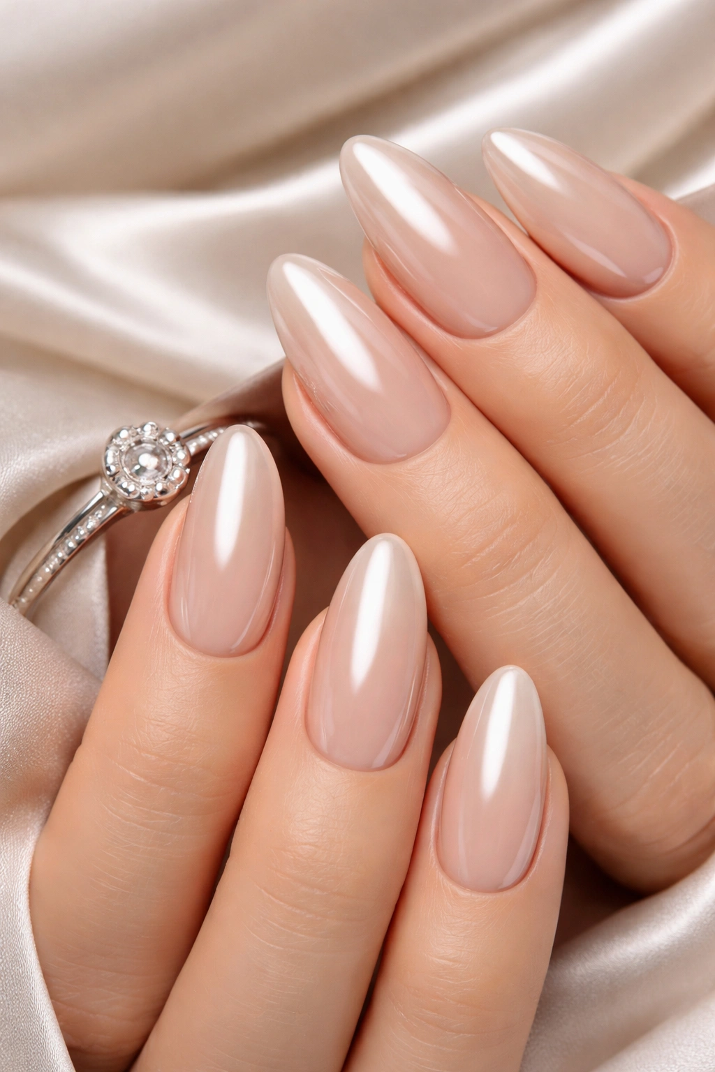 Nude chrome nails with a reflective metallic finish on almond nails