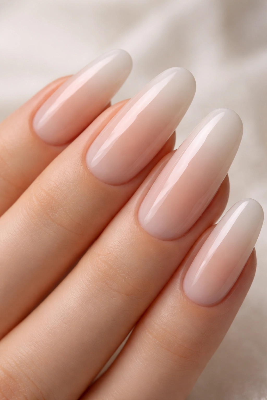 Close-up of nude gradient milk bath nails on long oval nails