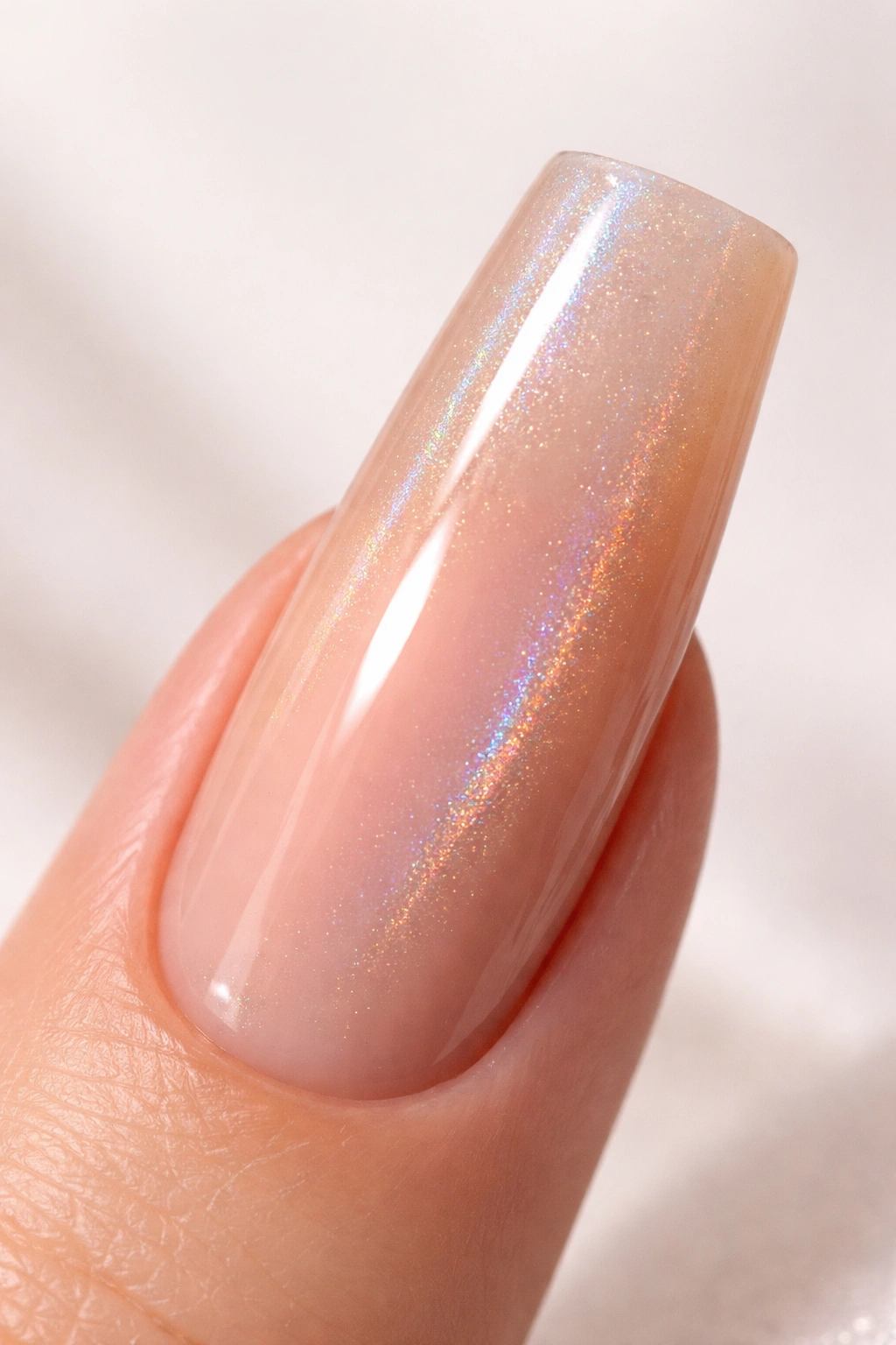 Close-up of a duck nail with glossy nude base and holographic shimmer