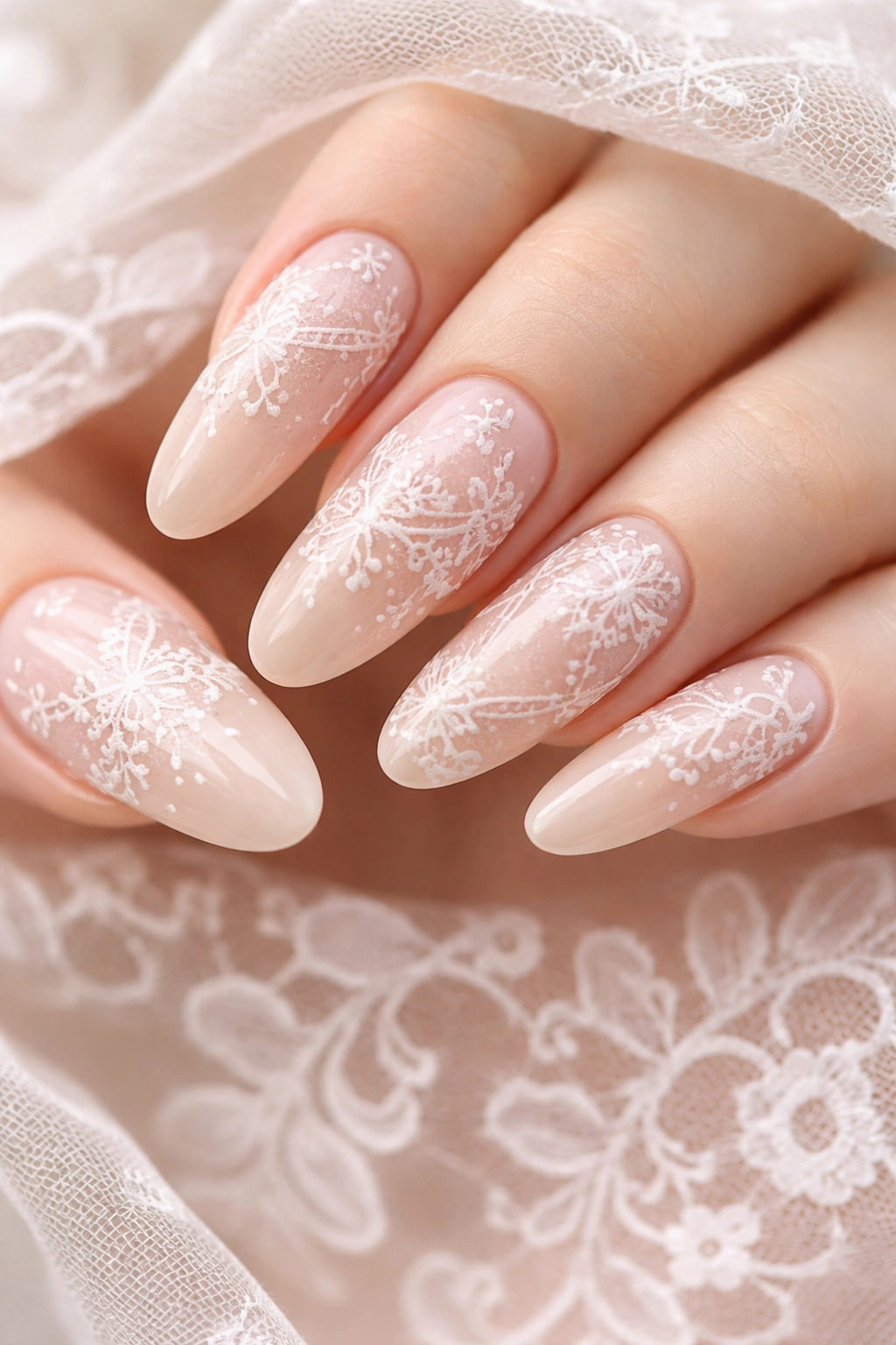 Nude nails with white lace patterns on long ovals