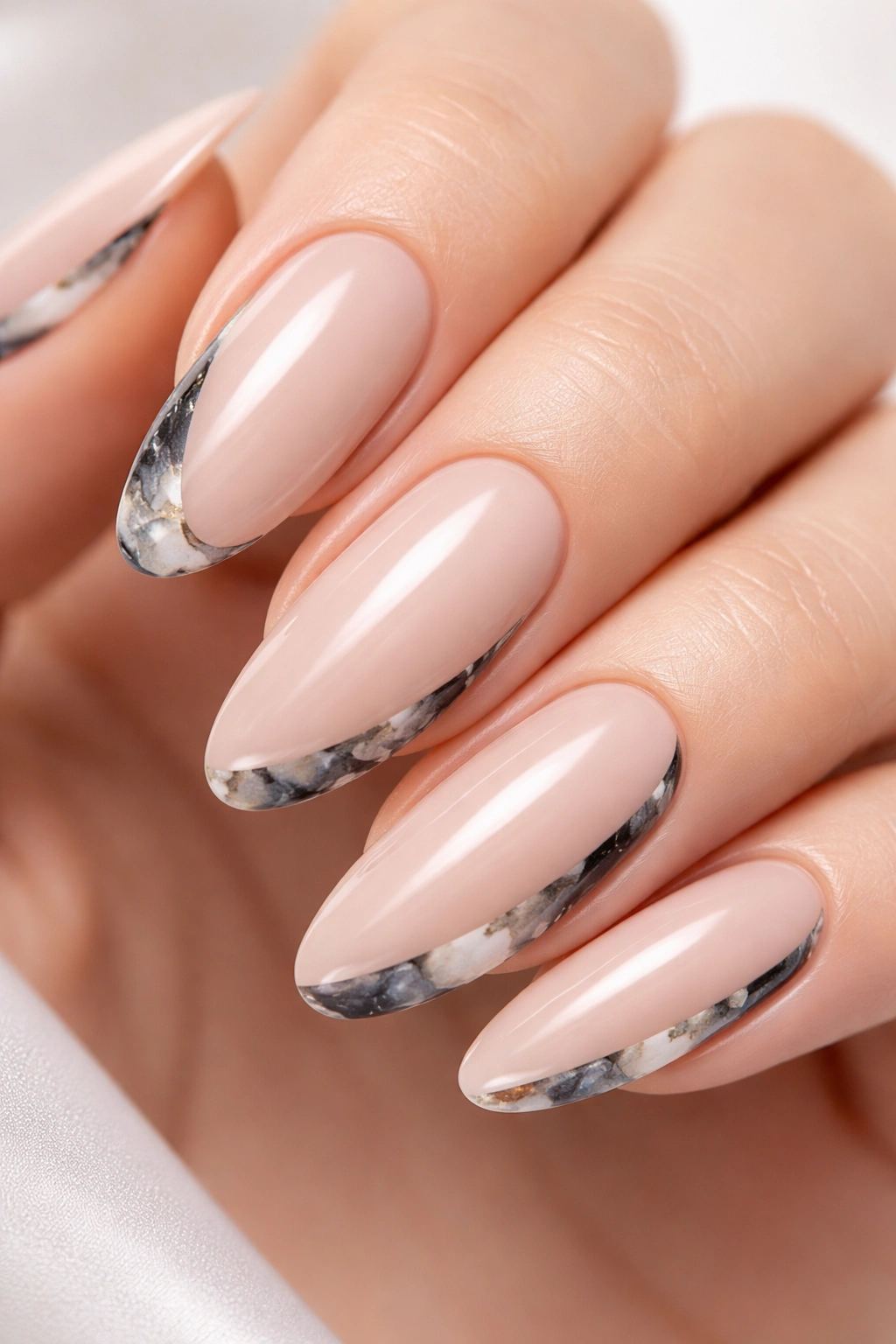 Close-up of nude nail with side marble accent in black gray white veins