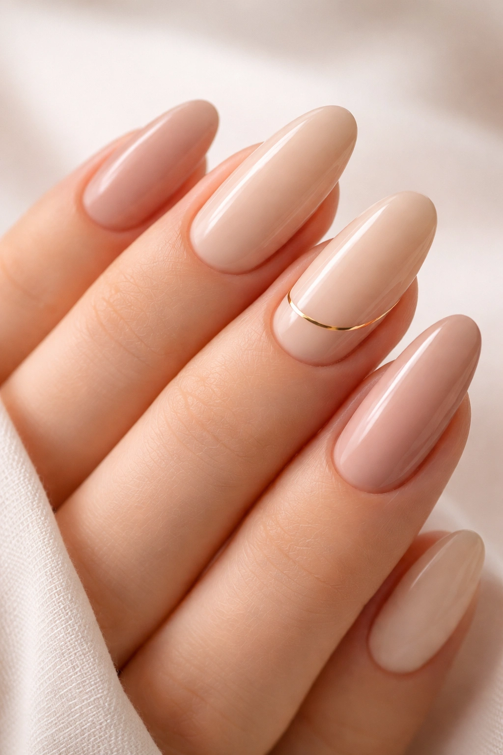 Nude nails with a subtle gold line accent on one nail