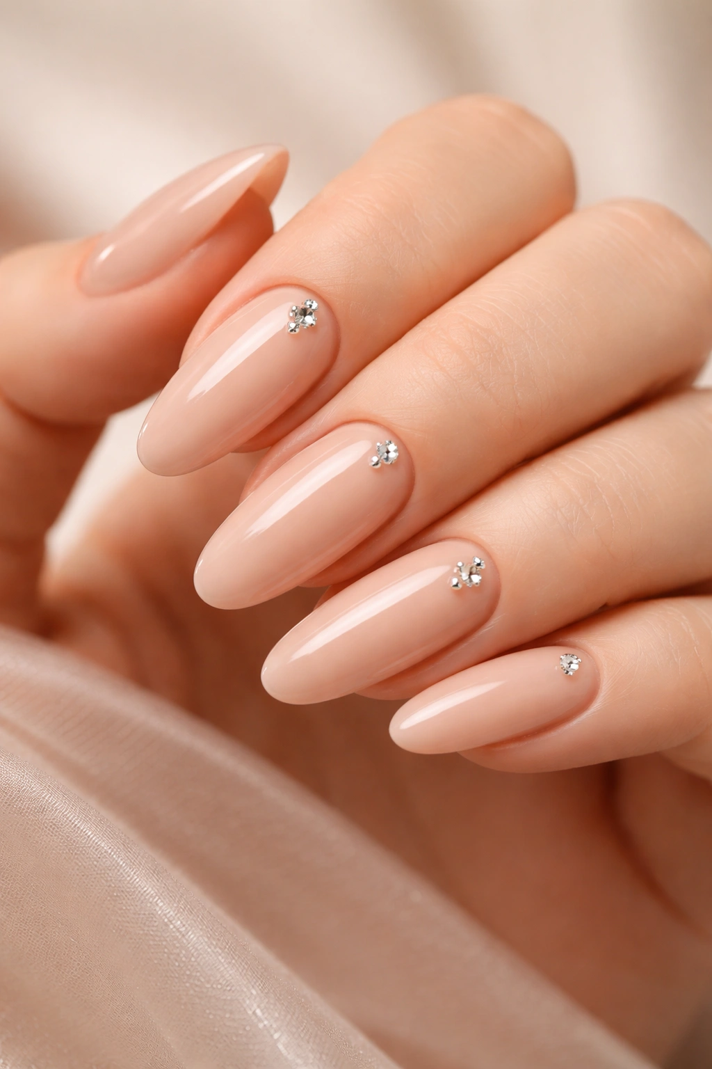 Nude nails with diamond studs on long oval nails
