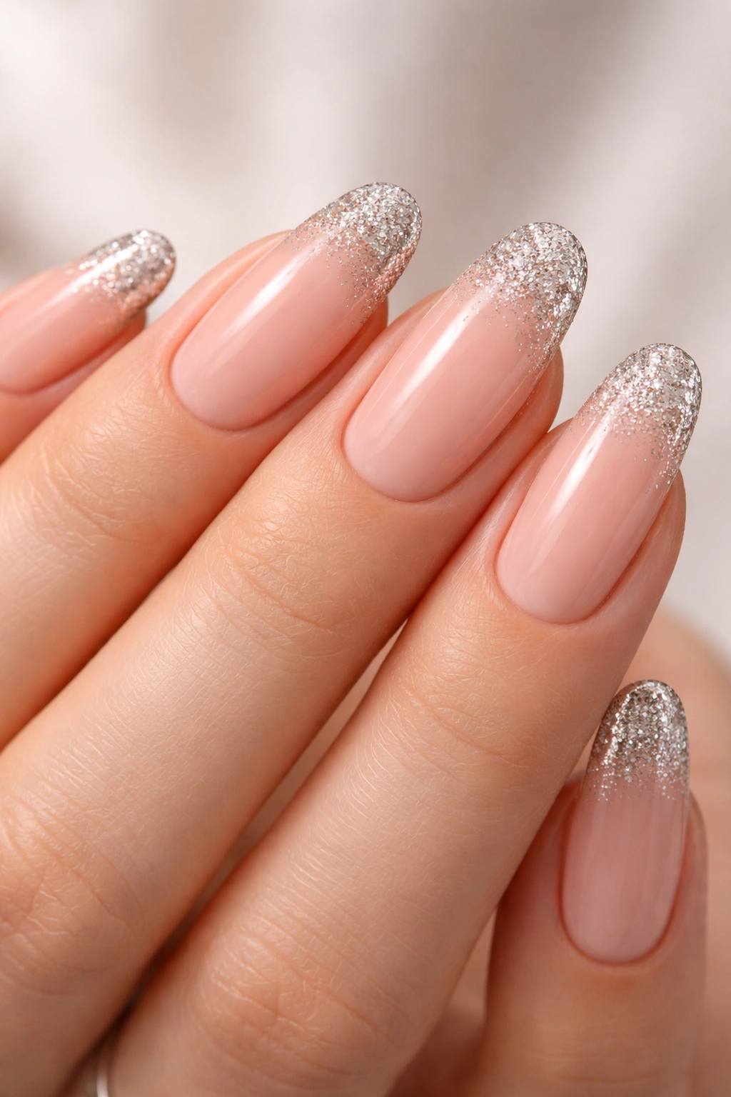 Nude nails with glitter tips on long oval shape