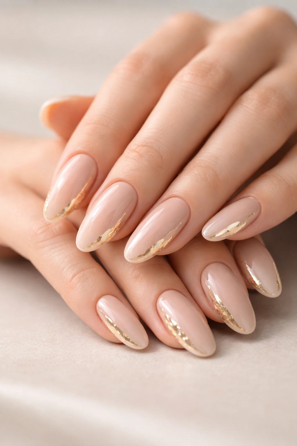 Soft nude long round acrylic nails with delicate gold foil edge detailing