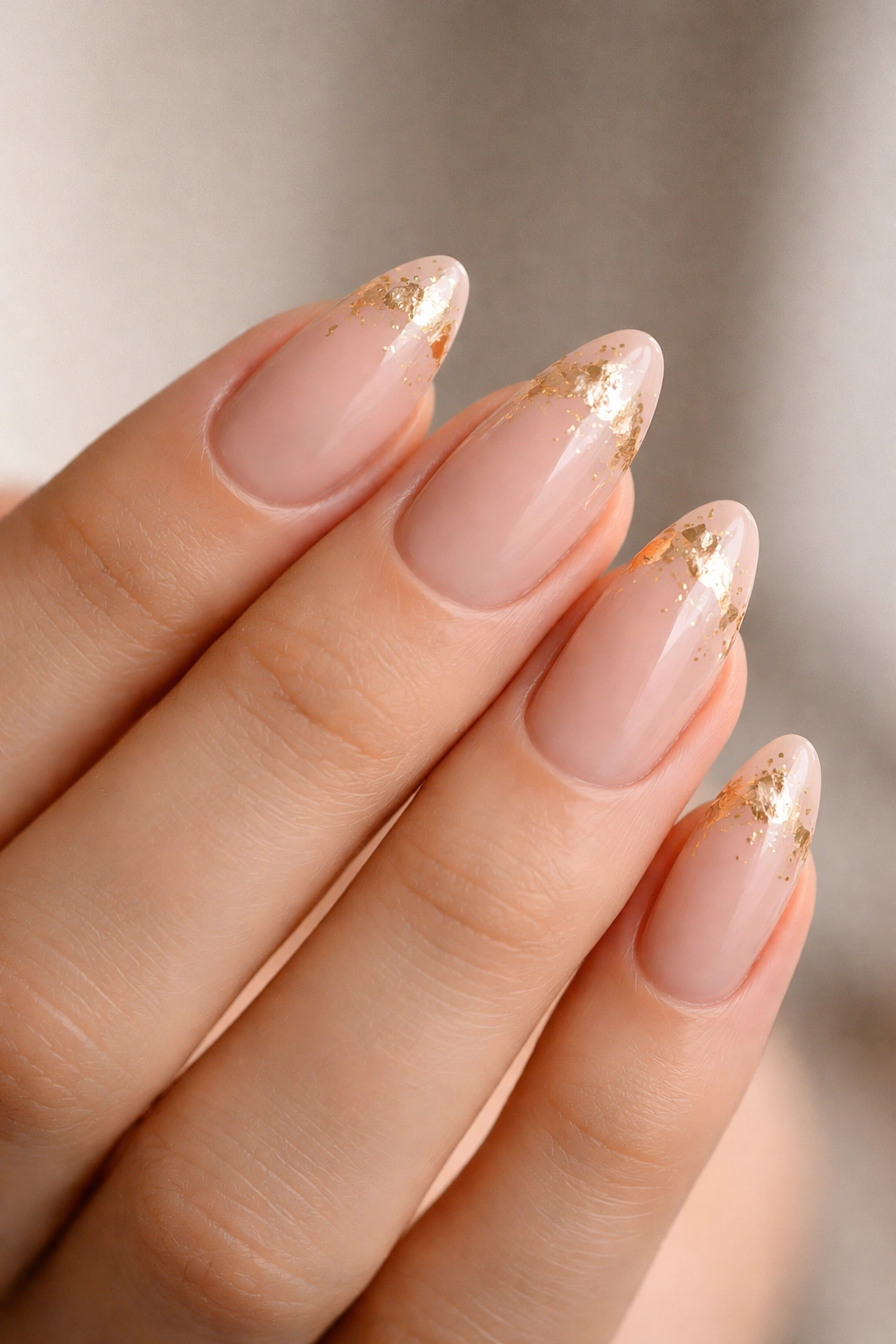 Nude almond nails with gold foil accents