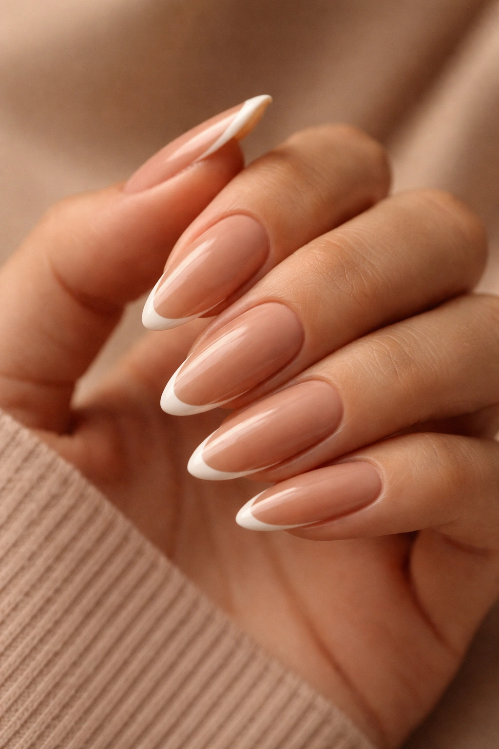 Long almond nails with a deep nude base and razor-thin white micro French line.