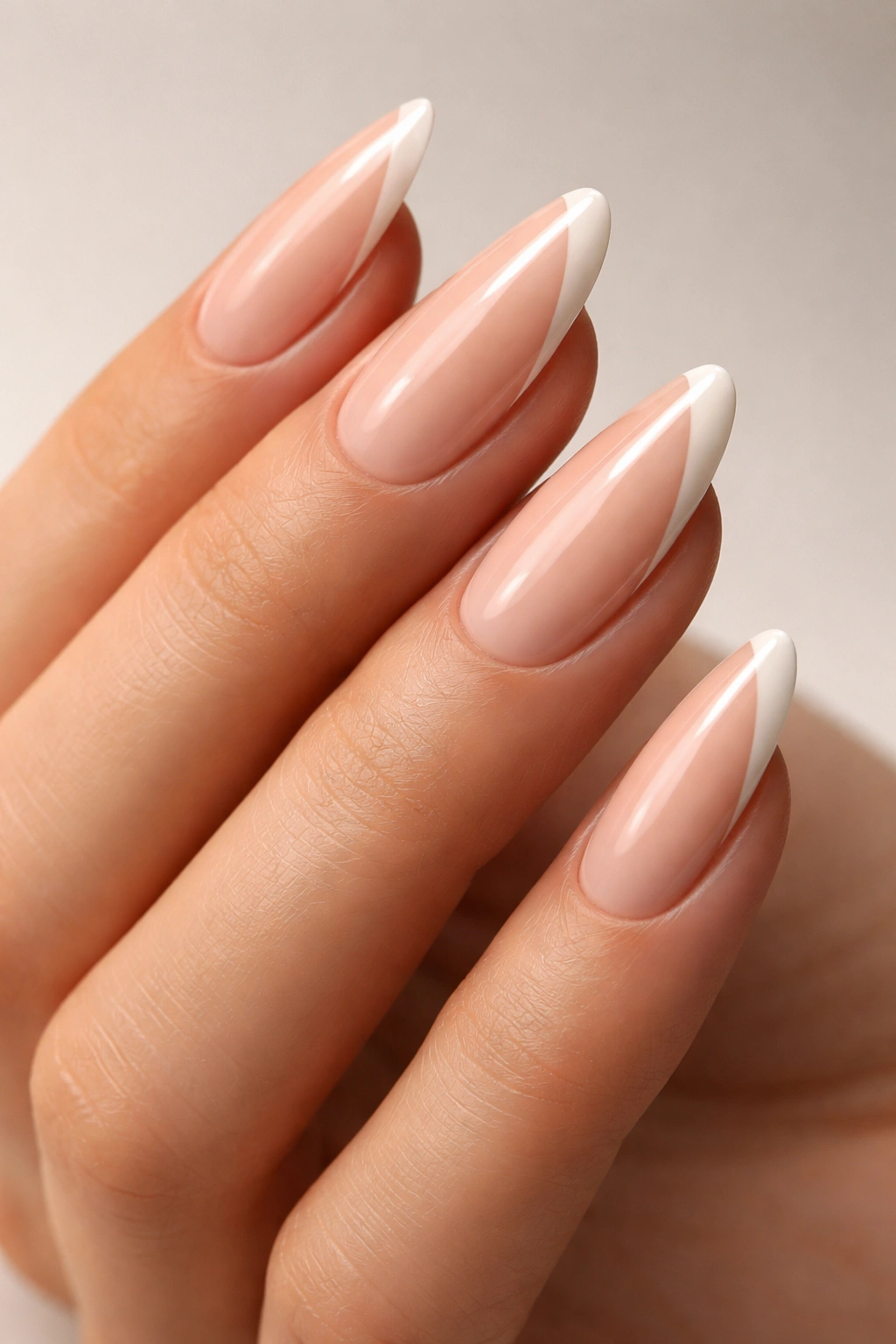 Close-up of nails with nude base and negative-space side art.