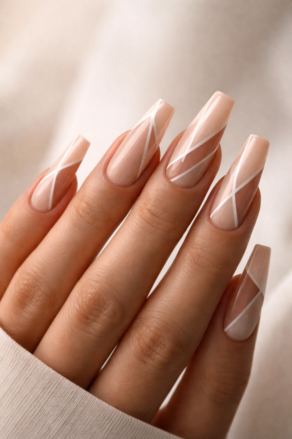 Nude nails with geometric negative-space patterns.