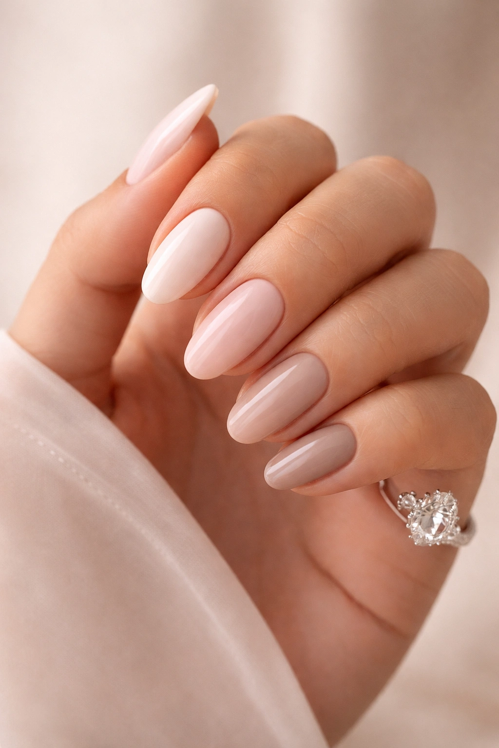 Close-up of nails painted in nude and neutral tones on a hand