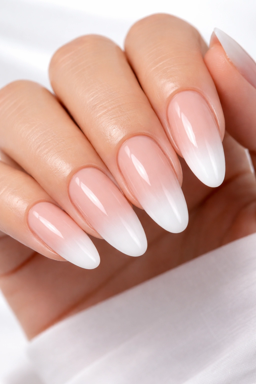 Nude oval nails with white ombre tips in a glossy finish