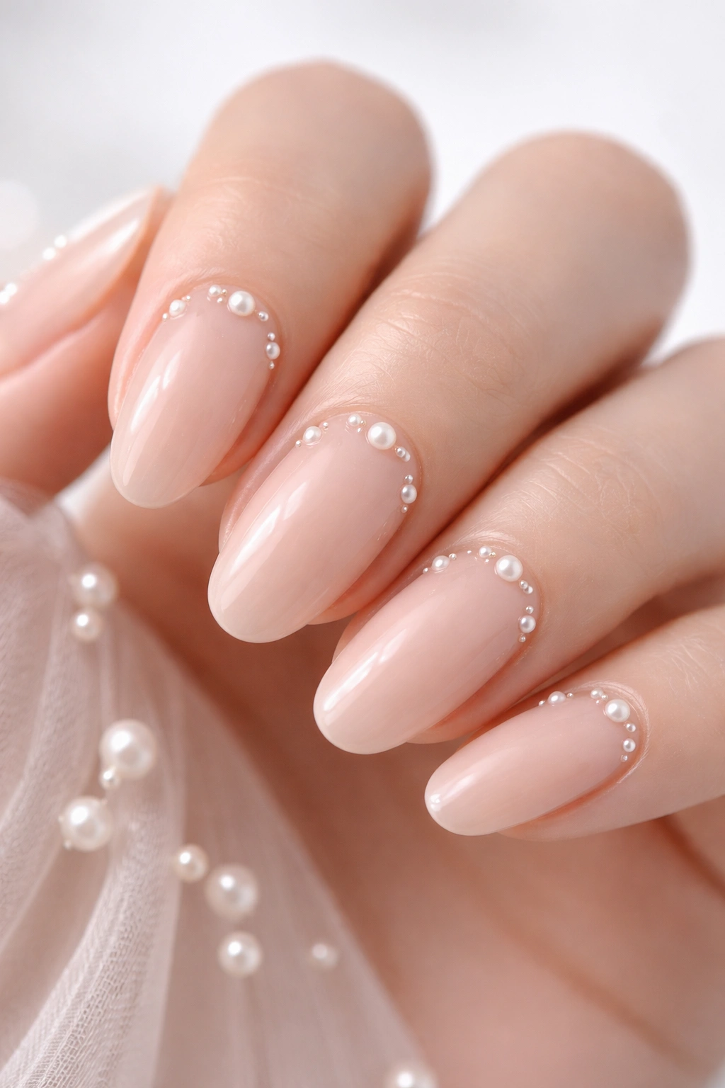 Close-up of nude nails with tiny pearl accents