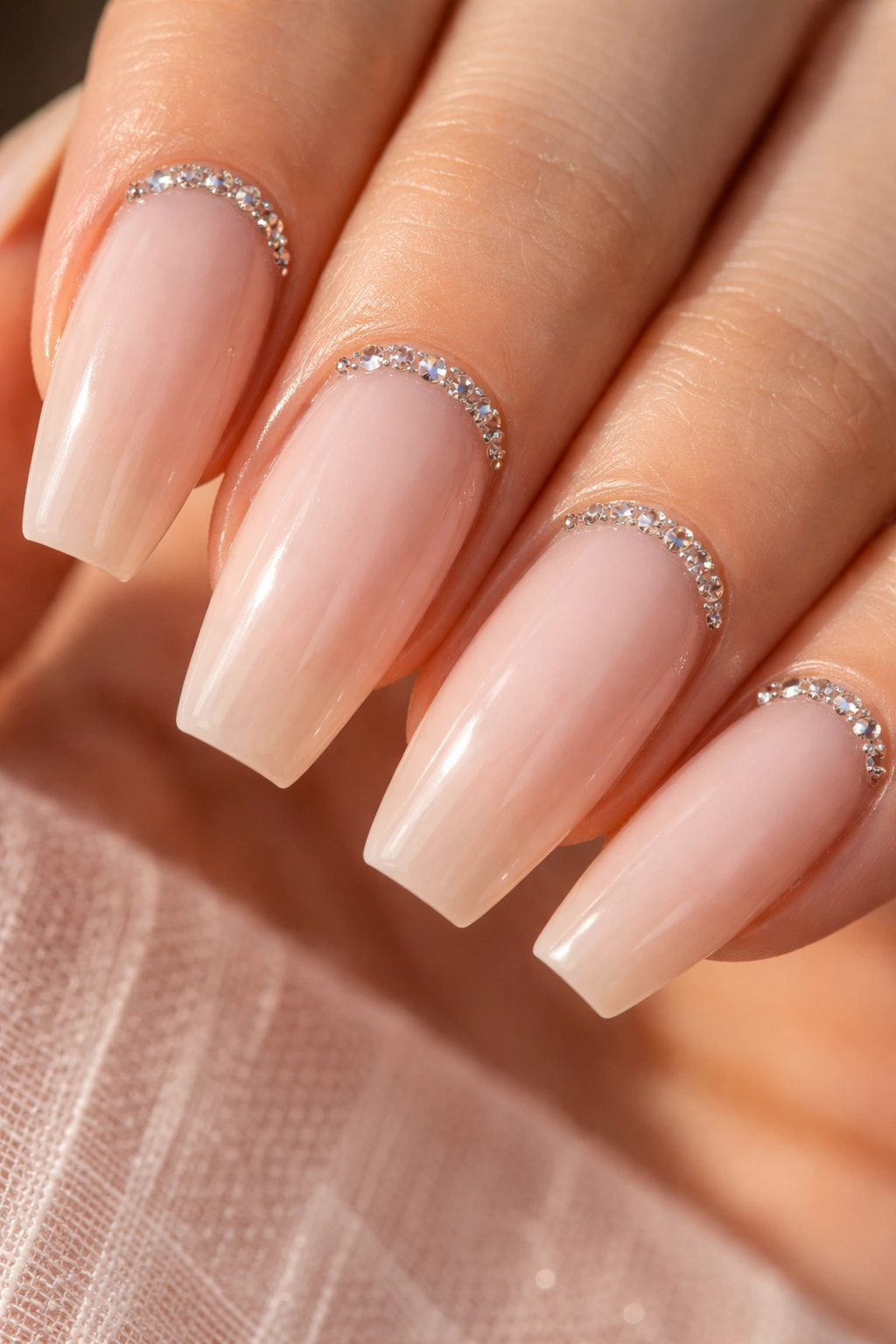 Nude ballerina nail with a tiny rhinestone cuticle arc.