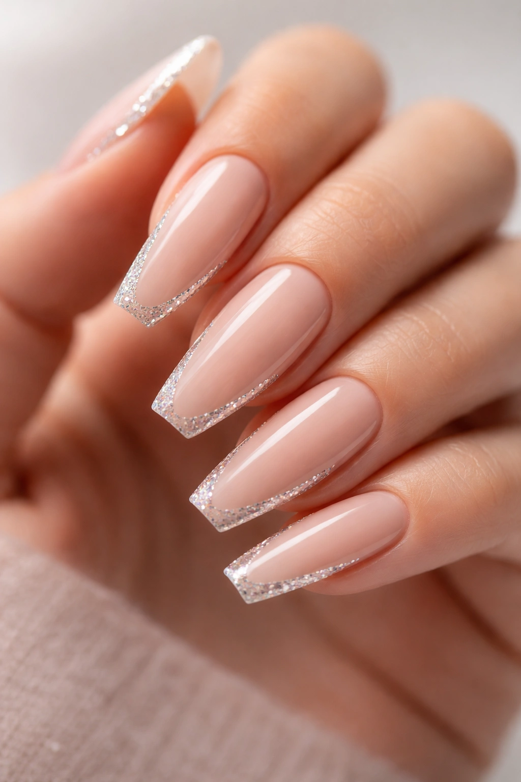 Nude nails with crystal-cut side glitter framing the sides