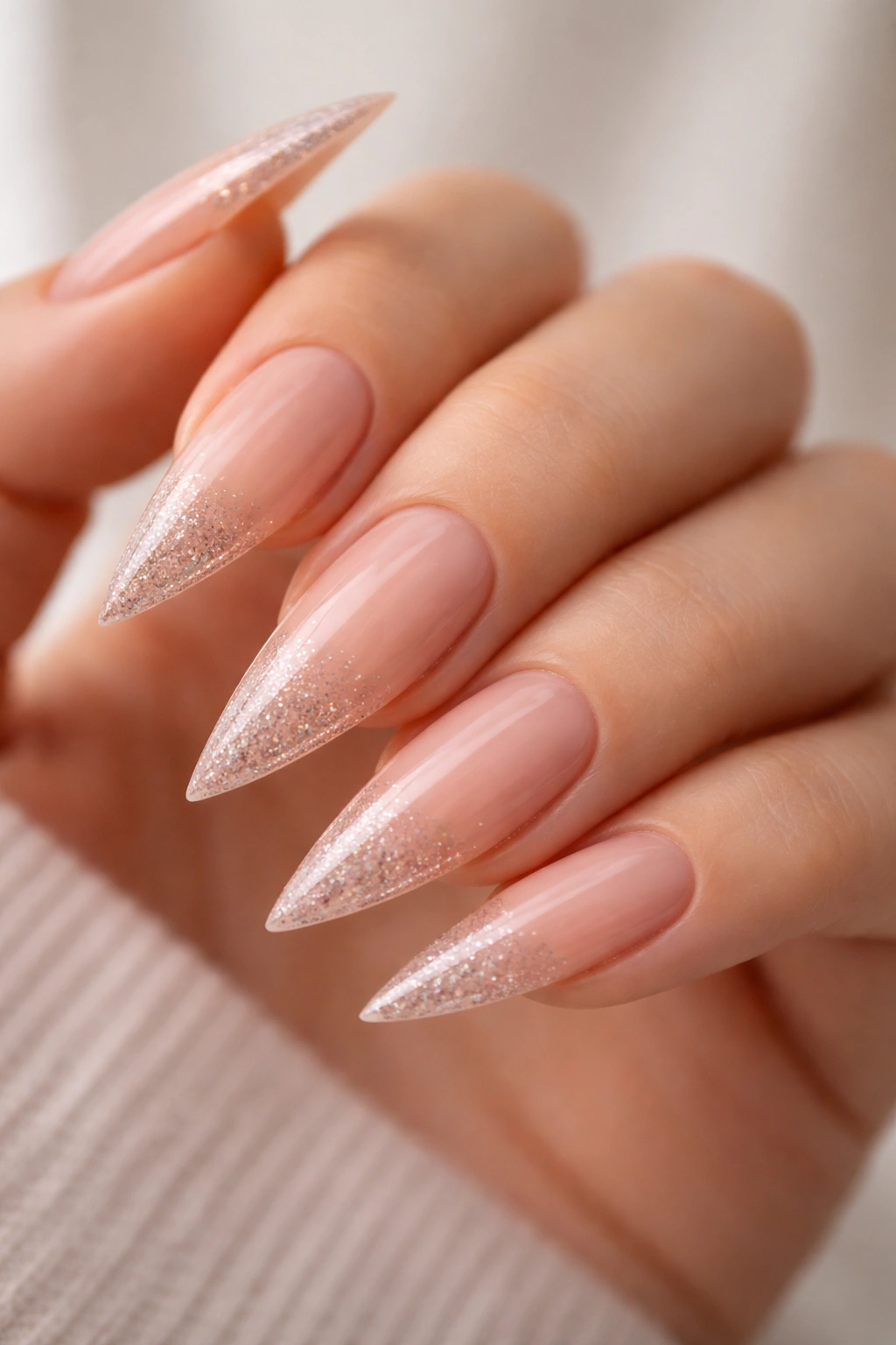 Nude stiletto nails with a subtle sparkle gradient