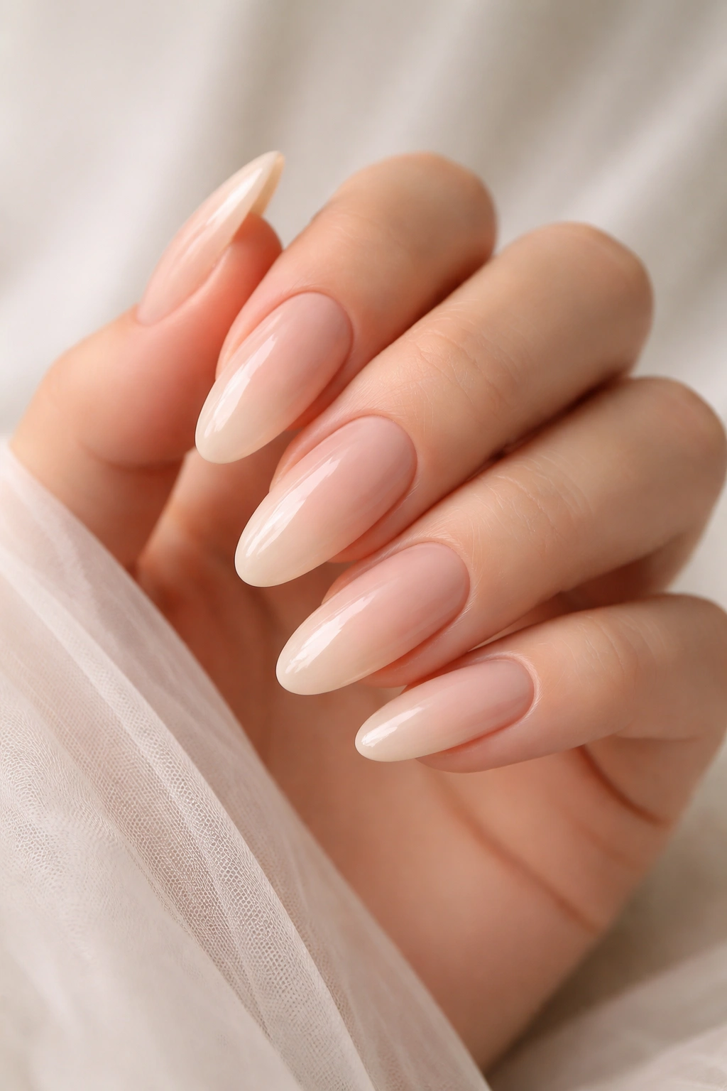 Close-up of nude ombré nails showing a gradient on a hand