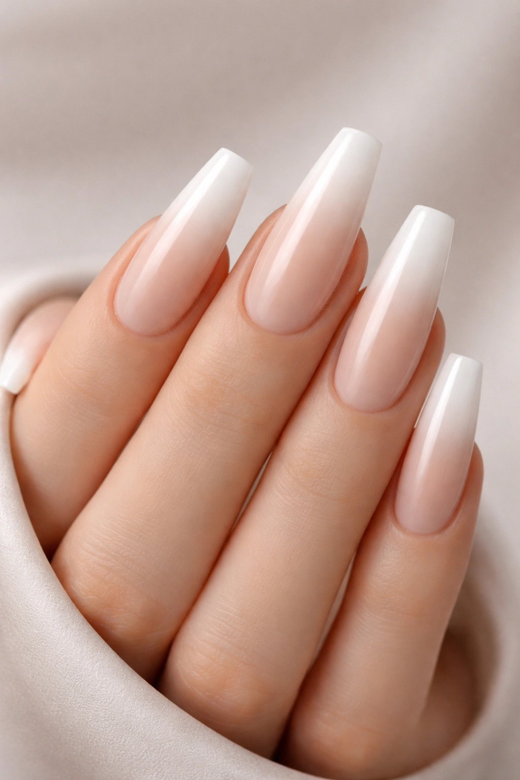 Close-up of nude-to-white ombre coffin nails with smooth gradient
