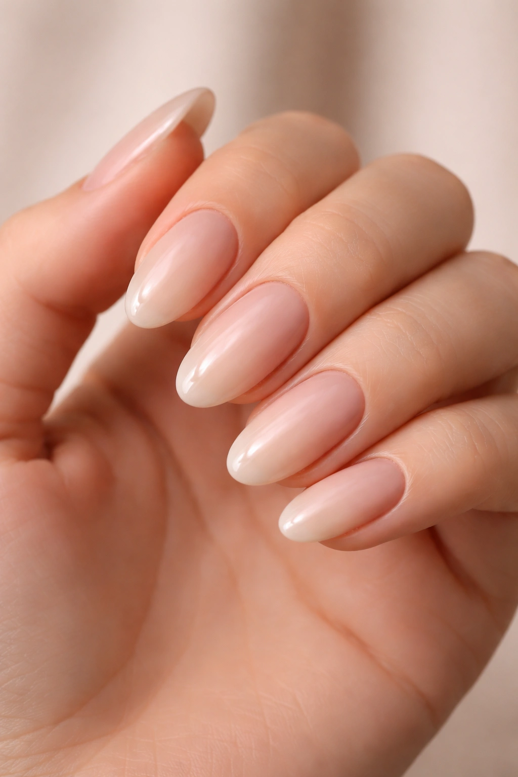 Nude ombré oval nails with seamless gradient on hand