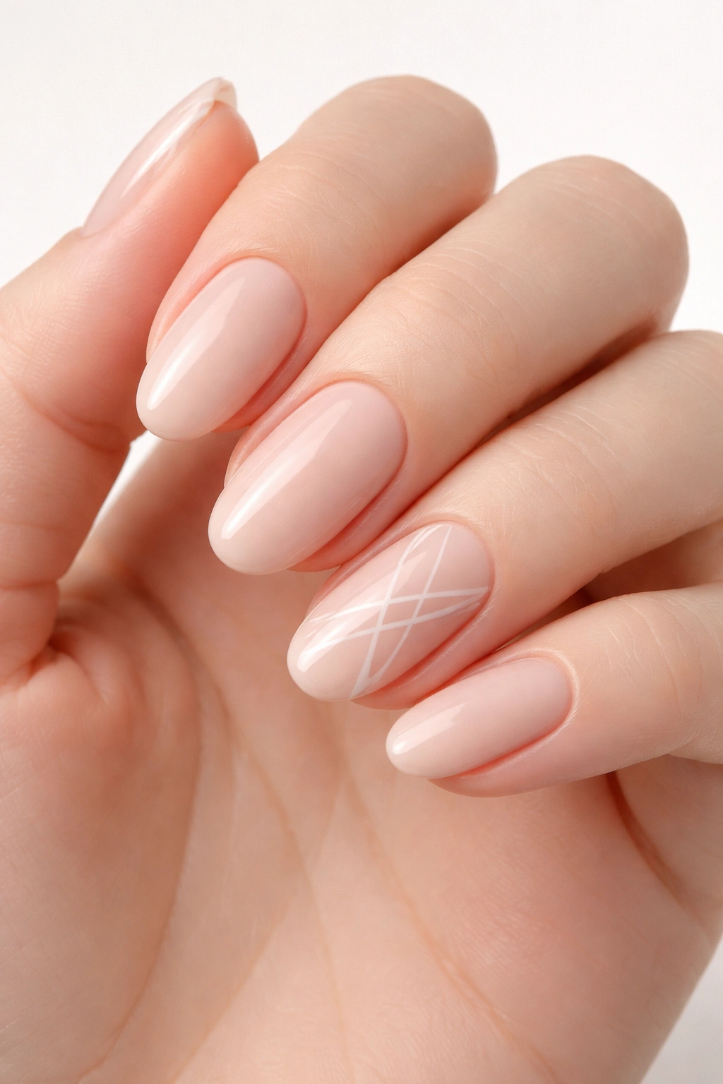 Oval nails with nude base and white geometric lines on an accent nail