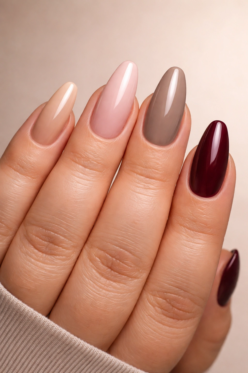 Nails painted in nude pink taupe burgundy to flatter fuller fingers