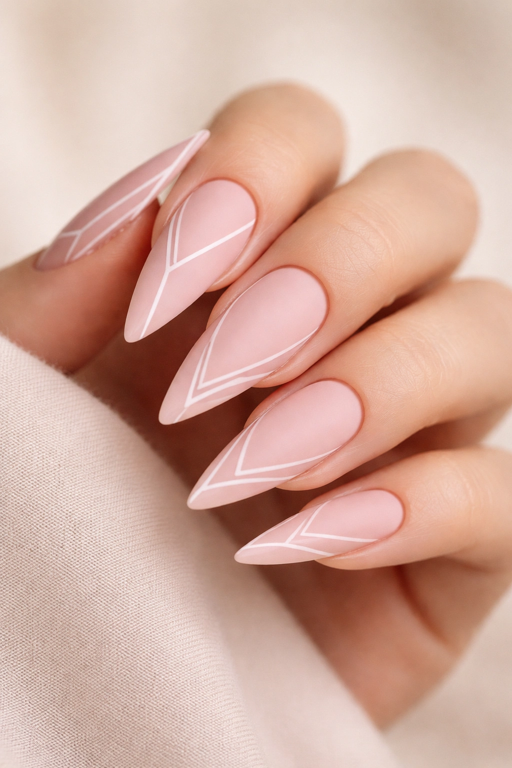 Nude pink matte stiletto nails with geometric outline