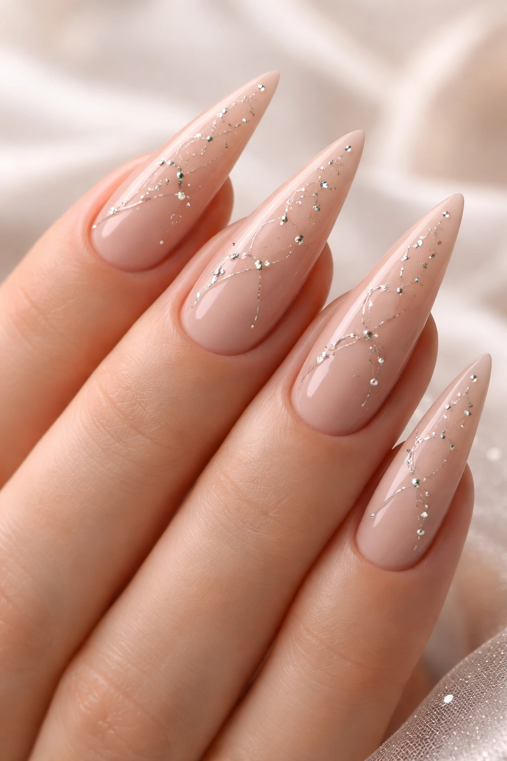 Close-up of nude stiletto nails with tiny diamond studs