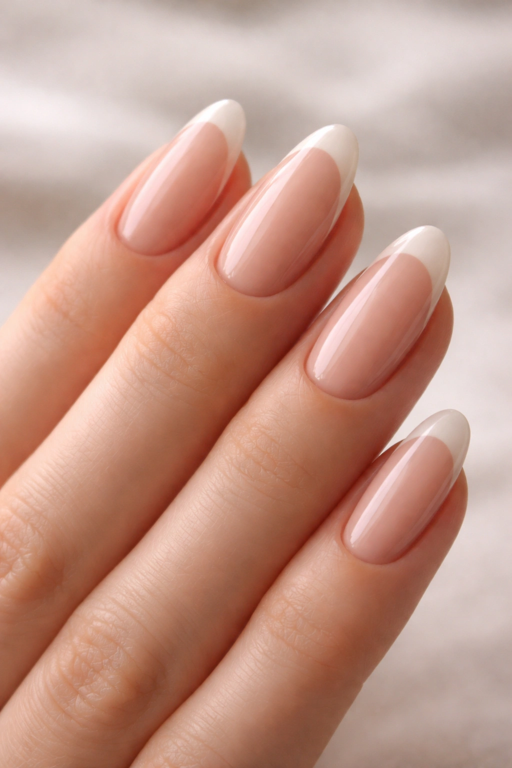 Close-up of hands with nude-tip reverse French manicure for an elongating natural look