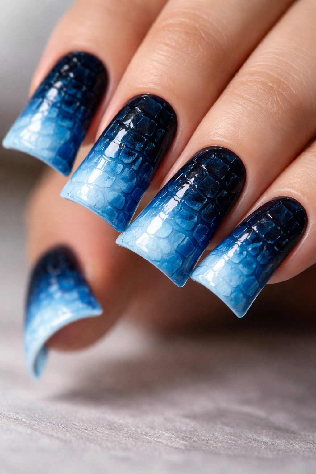 Duck nails in deep ocean blue with croc texture and a gradient fade at the tip