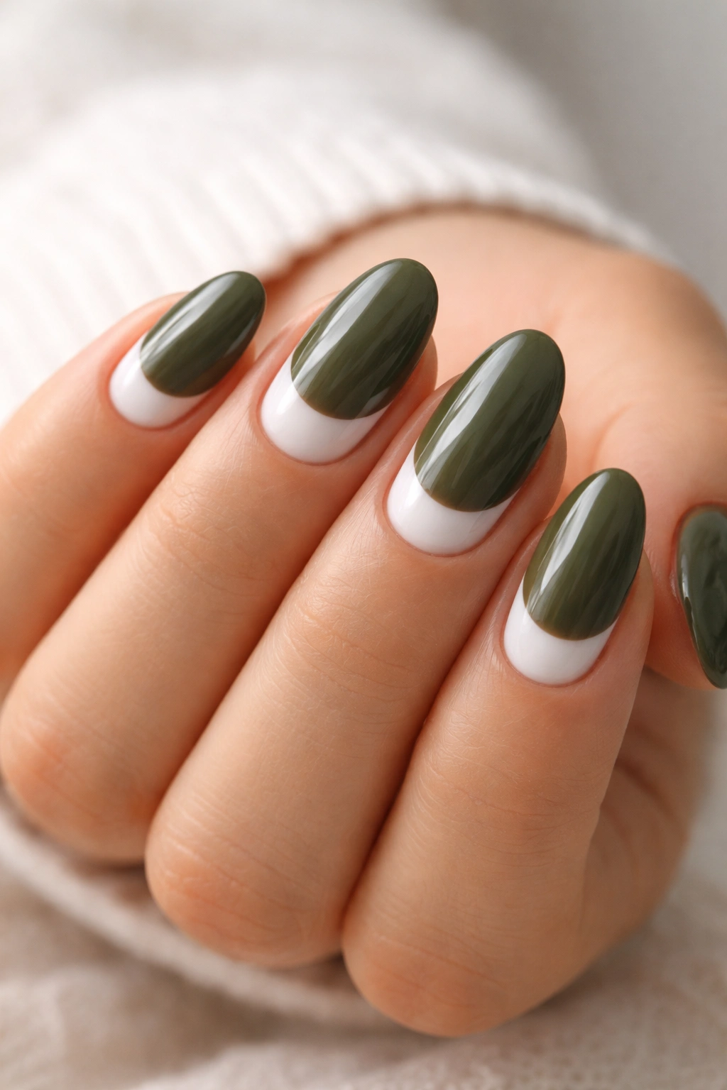 Short almond nails with milky white half-moons and olive green tips