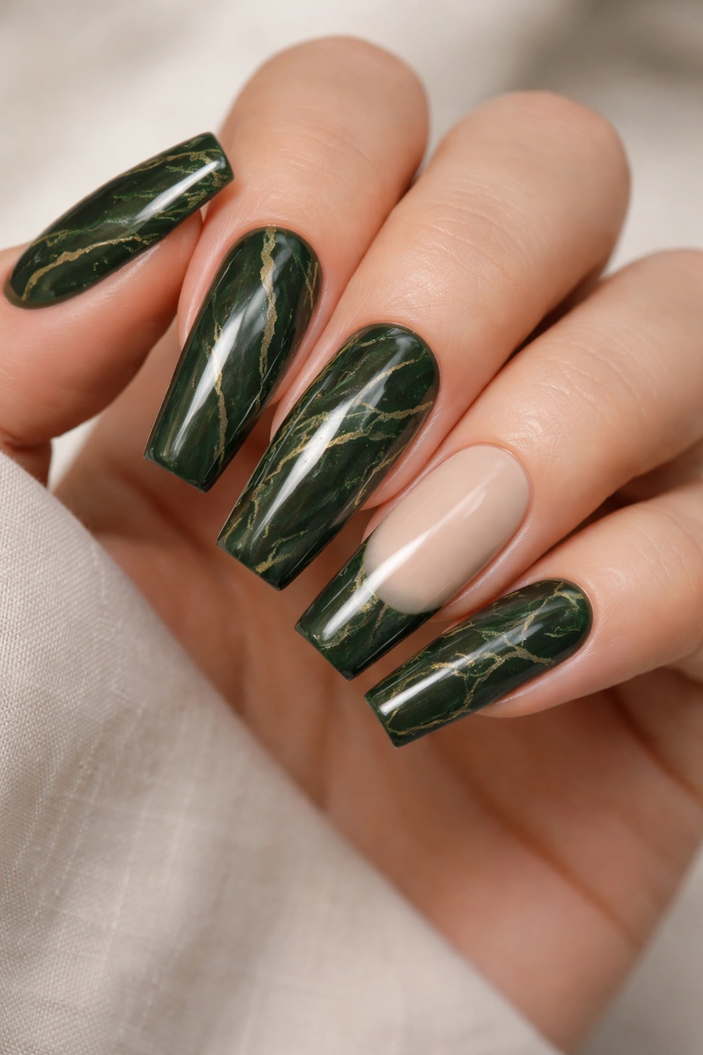 Close-up of dark olive-green marble coffin nails with nude accent nails