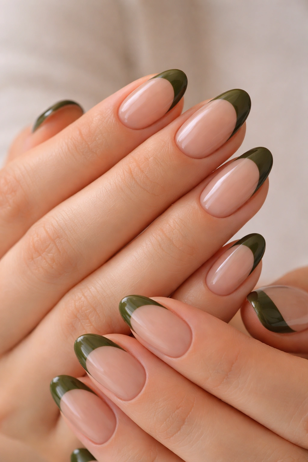 Short almond nails with olive green French tips on a nude base