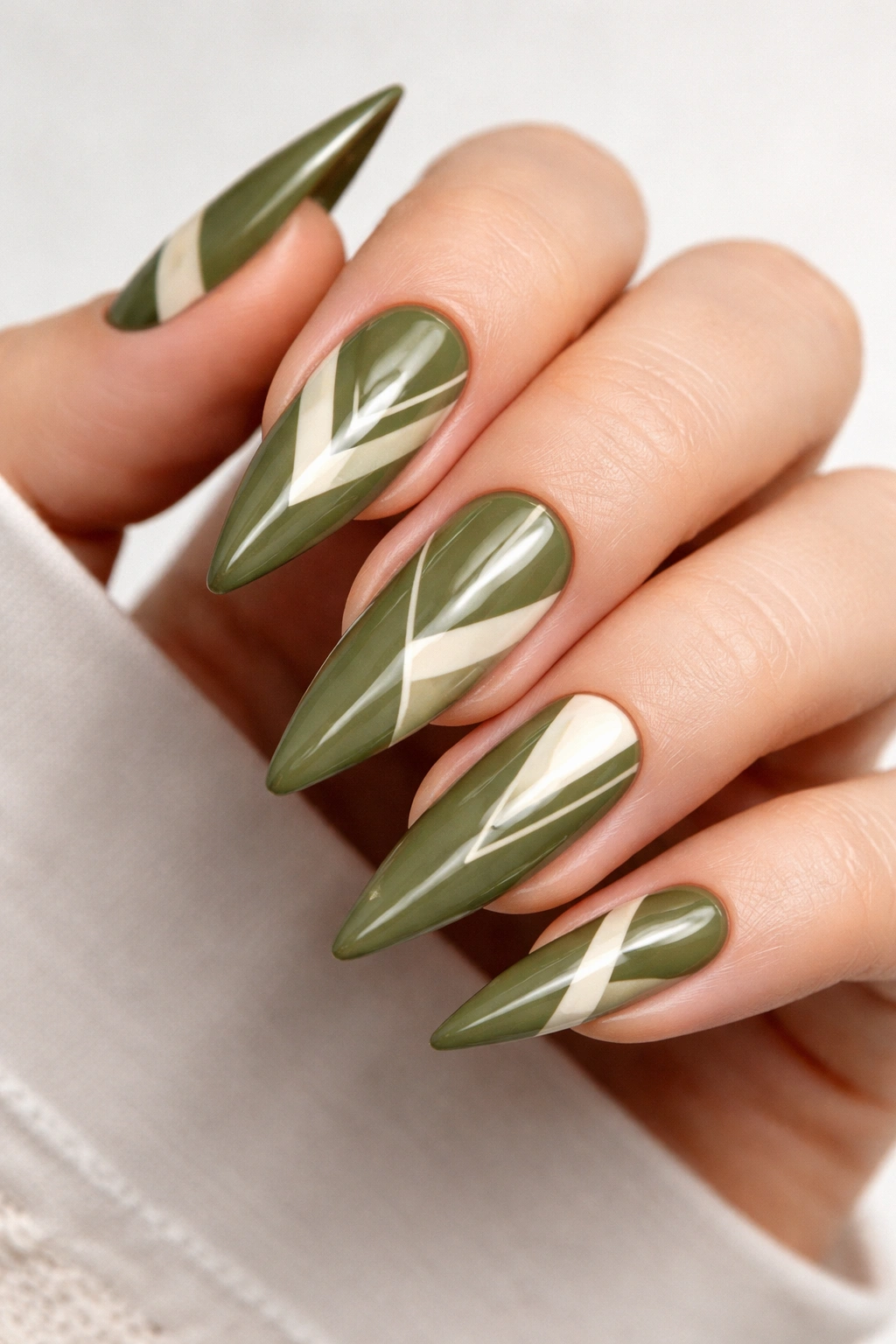 Olive green stiletto nails with geometric patterns