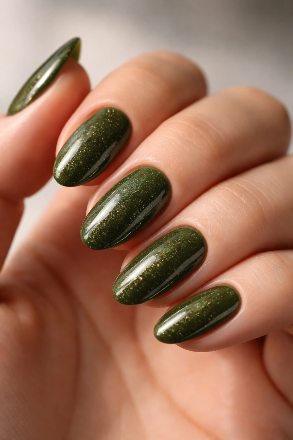 Short almond nails with deep olive base and fine micro glitter