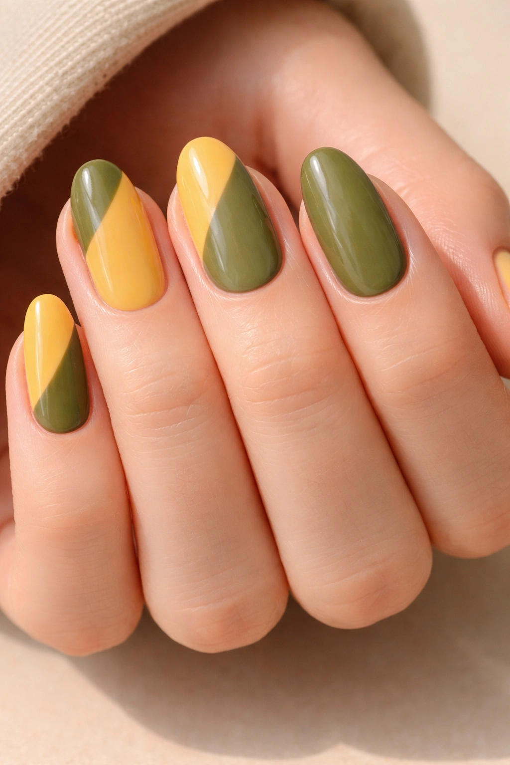 Close-up of short almond nails with olive and mustard color blocking