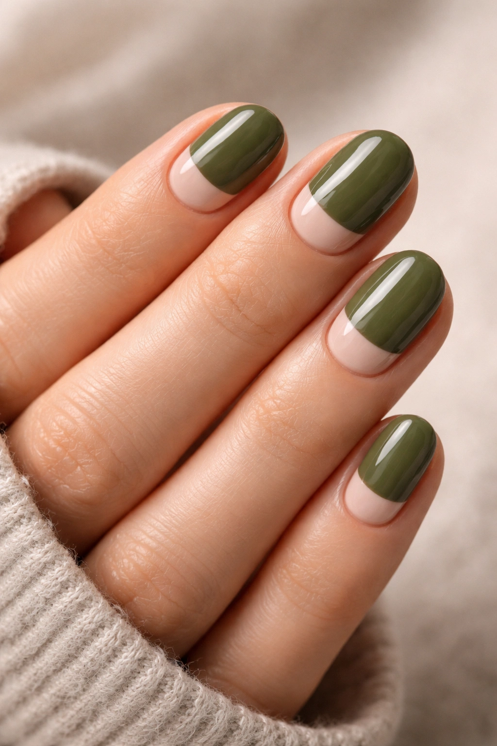 Close-up of olive and nude half-moon nails on short oval nails with a nude crescent near the cuticle