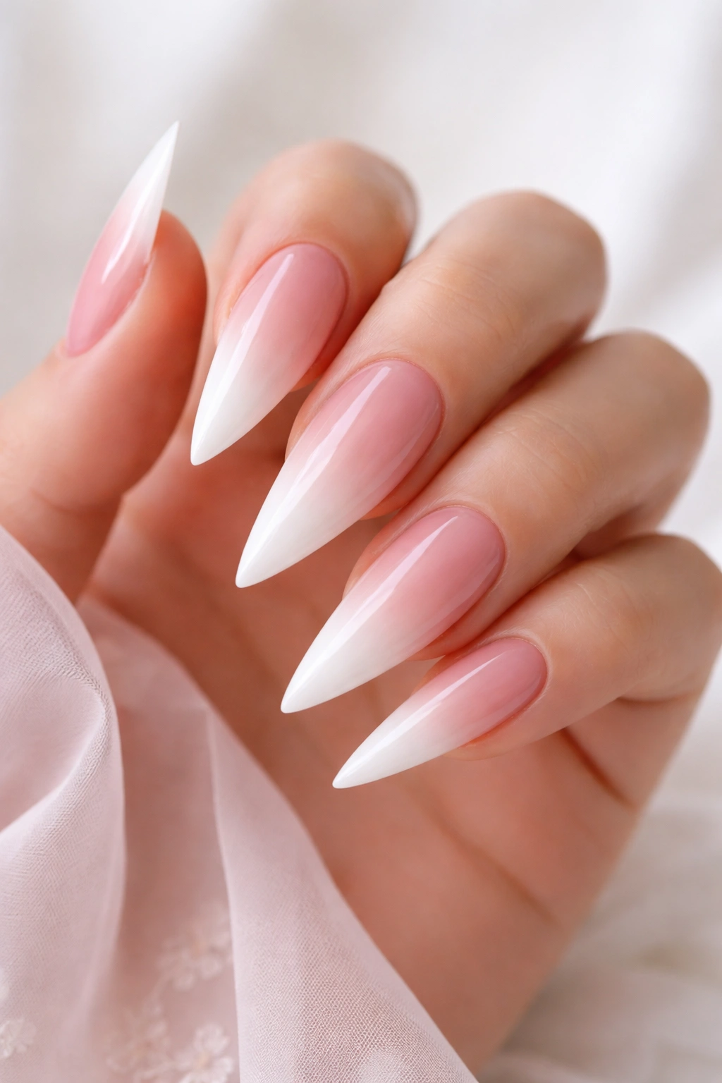 Close-up of ombré blush-to-white stiletto nails