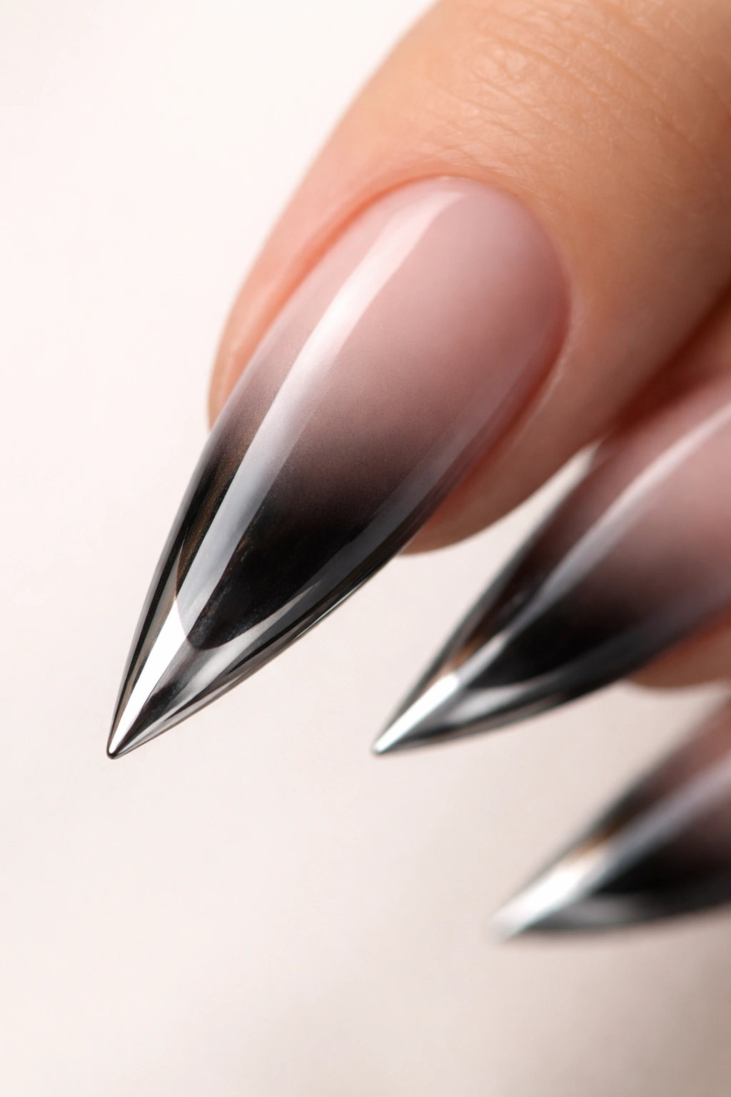Close-up of an ombre stiletto nail with chrome tip