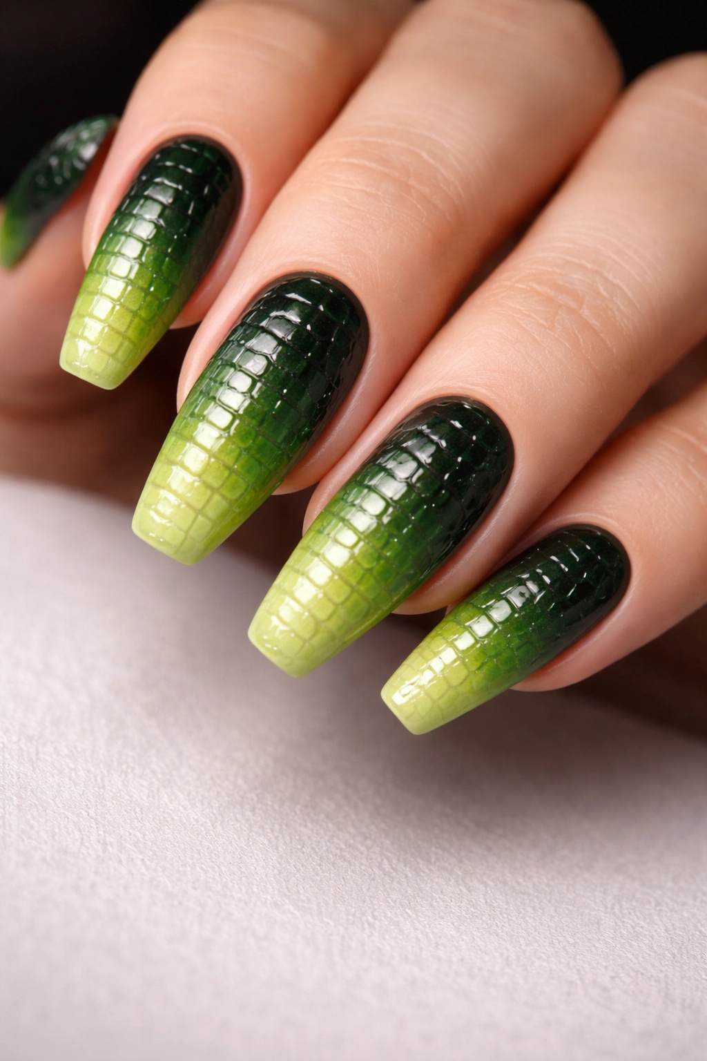 Close-up of ombré crocodile nails with green gradient and textured scales