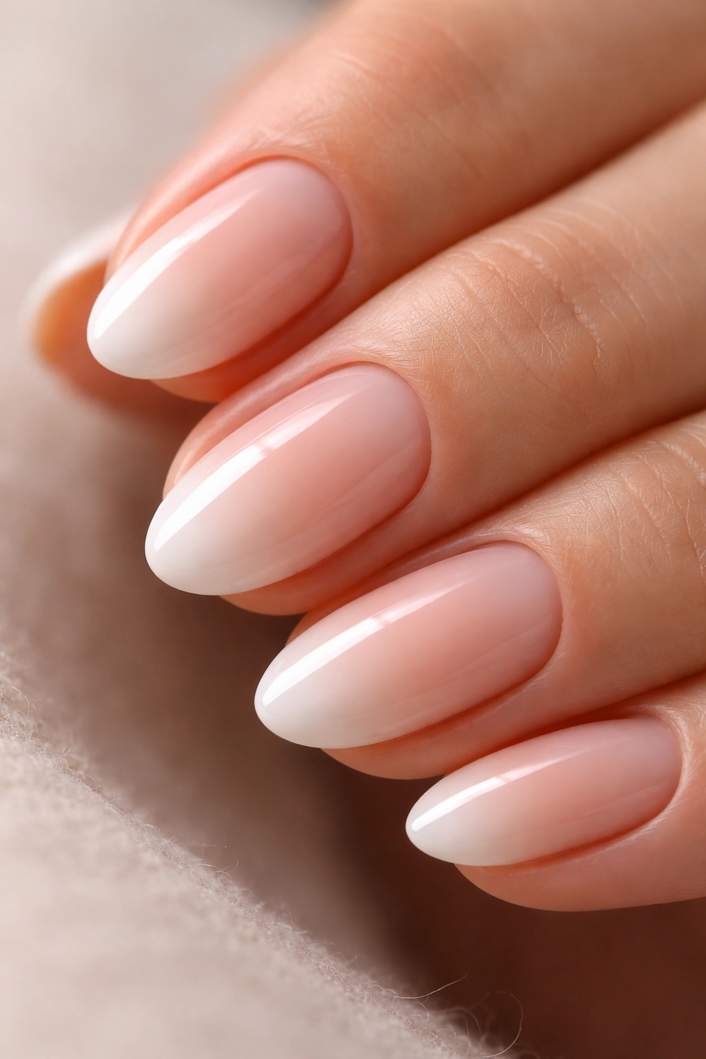 Close-up of short almond nails with ombré tips fading into the base